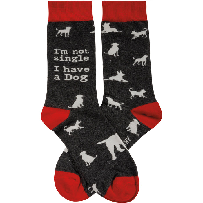 Crew socks in dark gray with red cuffs. White dog silhouettes and the text 'I'm not single I have a Dog' are printed on the socks. }}