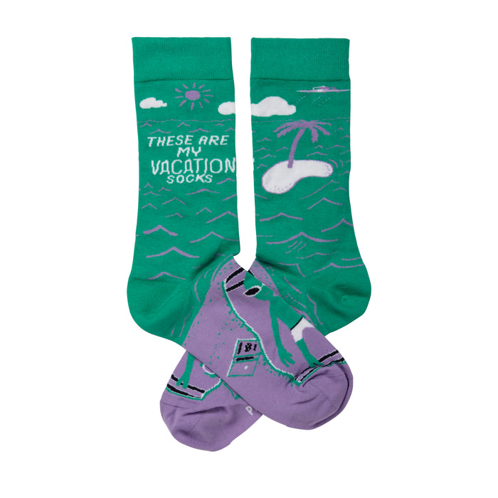 Crew socks in teal green and lavender purple. Design includes a beach scene with a palm tree, sun, and a person surfing. }}