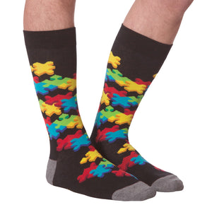 Flat lay showcasing both socks with the colorful puzzle piece design.