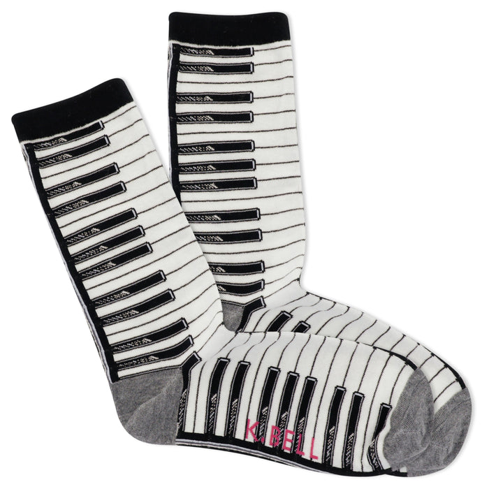 A pair of cream crew socks with a black and white piano key pattern. The cuffs are black, and the bottom is grey. }}