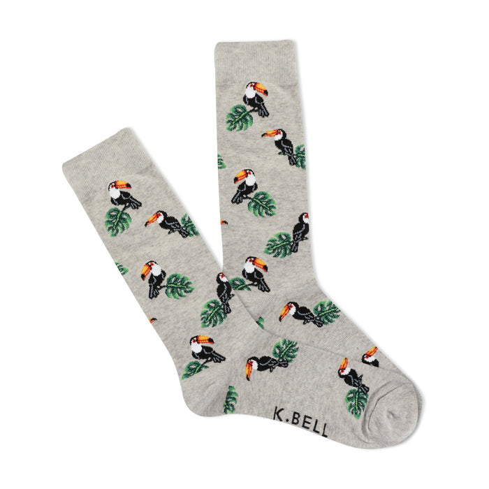 A pair of light gray crew socks with a repeating pattern of pixelated toucans and green leaves.  The socks are folded slightly. }}