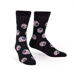 Black crew socks with a repeating pattern of purple and red eyeball designs. The socks glow in the dark.