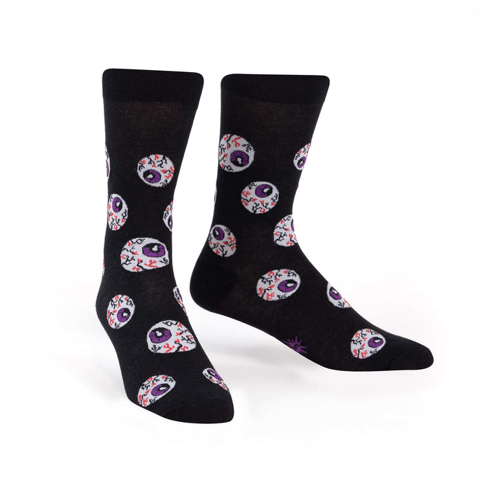 Black crew socks with a repeating pattern of purple and red eyeball designs. The socks glow in the dark.