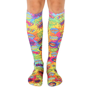 Knee-high socks in a tie-dye pattern of bright yellow, pink, and blue.  Comic book-style words like 'POW!' and 'BAM!' are printed throughout.