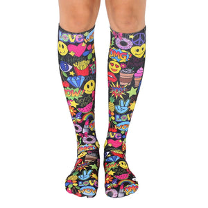 Knee-high socks in black with a colorful all-over print of smiley faces, peace signs, and other fun 90s-style graphics.