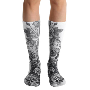 A pair of white crew socks with a gray sugar skull and rose design. The skulls have floral details.