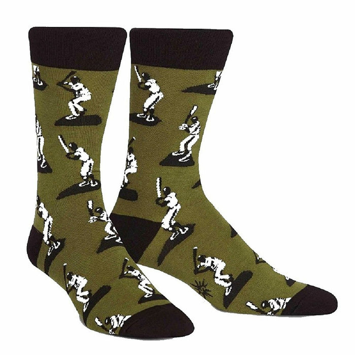 A pair of men's crew socks in olive green with a repeating pattern of white baseball players batting. The socks have black cuffs. }}