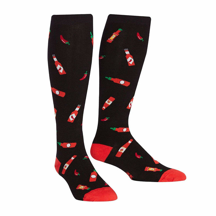 Pair of black knee-high socks with a pattern of red hot sauce bottles and chili peppers.  The socks have red cuffs. }}