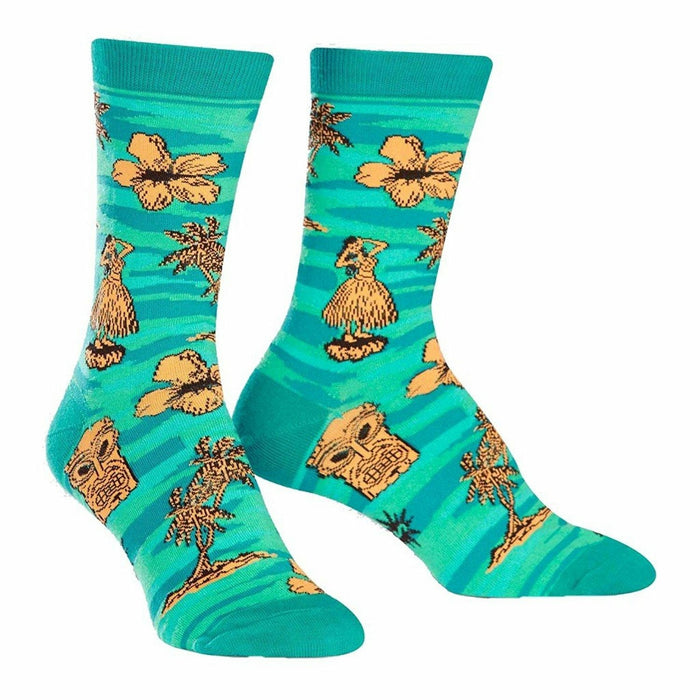 Crew socks in teal, adorned with orange hibiscus flowers, hula dancers, tiki masks, and palm trees. A fun, tropical design. }}