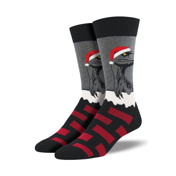 Crew socks in black, gray, and red. The design shows raptors wearing Santa hats, peeking from a snowy scene. The foot area has a bold stripe pattern. }}