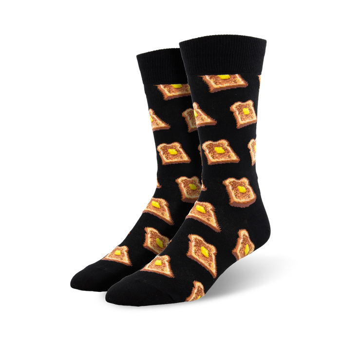 A pair of black crew socks with a repeating pattern of illustrated pieces of toast and butter. }}