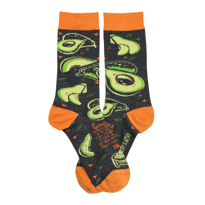 Crew socks in dark gray with orange cuffs.  The pattern shows multiple bright green avocados in various slices, along with a guacamole recipe. }}