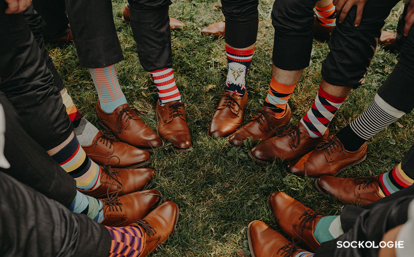 Groomsmen pulling up pant legs to show novelty socks