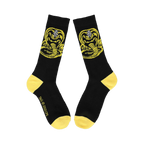 Flatlay product shot of a pair of black Cobra Kai socks with yellow accents showing the full Cobra Kai logo.