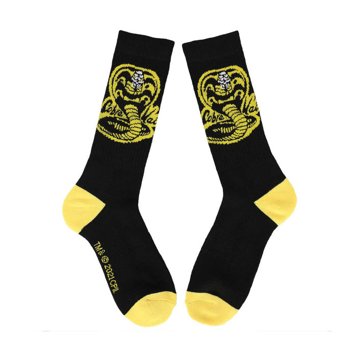 A pair of black socks with a yellow toe, heel, and cobra logo.