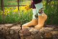 Lifestyle shot of a person wearing mint green and tan Van Gogh's Sunflowers socks. [lf]