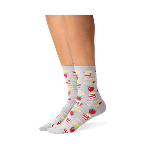 Lifestyle photo showing the socks on a person's legs; they are grey with a school supplies pattern.