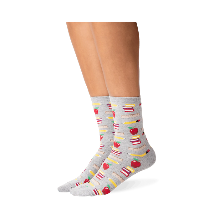 Lifestyle photo showing the socks on a person's legs; they are grey with a school supplies pattern.