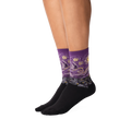 Lifestyle shot: A person's legs wearing a pair of purple Van Gogh's Starry Night socks.