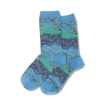 monet's waterlilies socks for women feature an all-over pattern of water lilies in shades of blue, green, and pink on a light blue background. the socks are blue at the top and the toes are dark green.  
