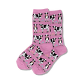 Pair of pink crew socks with a repeating pattern of black and white cows and small flowers. 