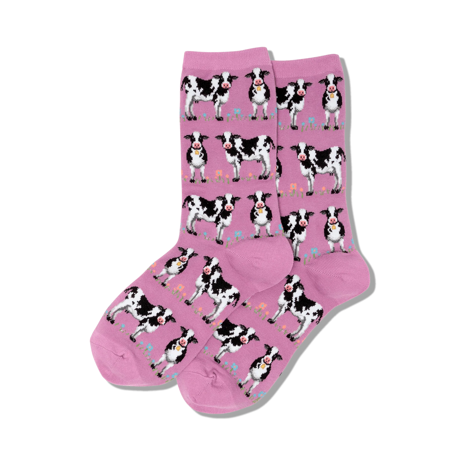 Pair of pink crew socks with a repeating pattern of black and white cows and small flowers. 