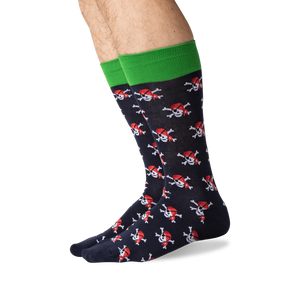 A pair of black socks with a green band at the top and a pattern of red pirate skulls with black eye patches and crossed bones.