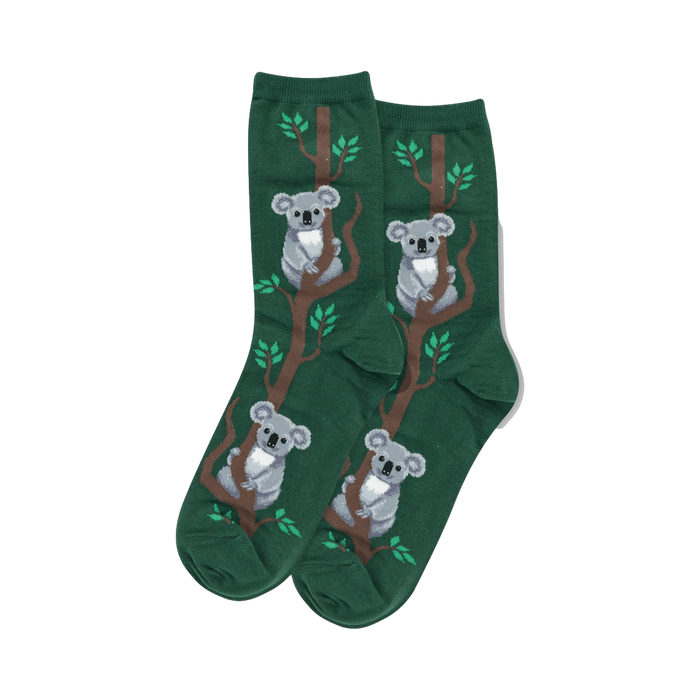 Pair of women's crew socks. Dark green background with a repeating pattern of grey koalas on brown branches with small green leaves. }}