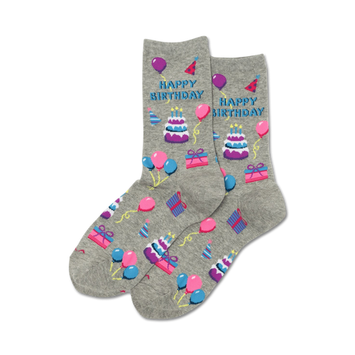 Pair of grey crew socks with a 'Happy Birthday' design. Features purple, pink, and blue pixelated cakes, balloons, and gifts.