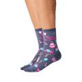 Lifestyle shot showcasing a woman's legs wearing the dark grey 'Happy Birthday' crew socks. The socks' design is clearly visible.