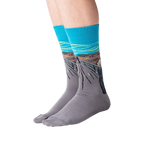 Flat lay of 'The Scream' socks in orange and teal showing full design.