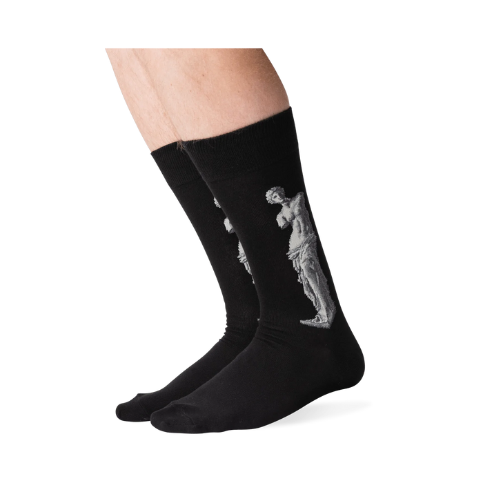 Lifestyle shot of a person's legs wearing the Venus de Milo socks. The socks are black with a white image of the Venus de Milo.