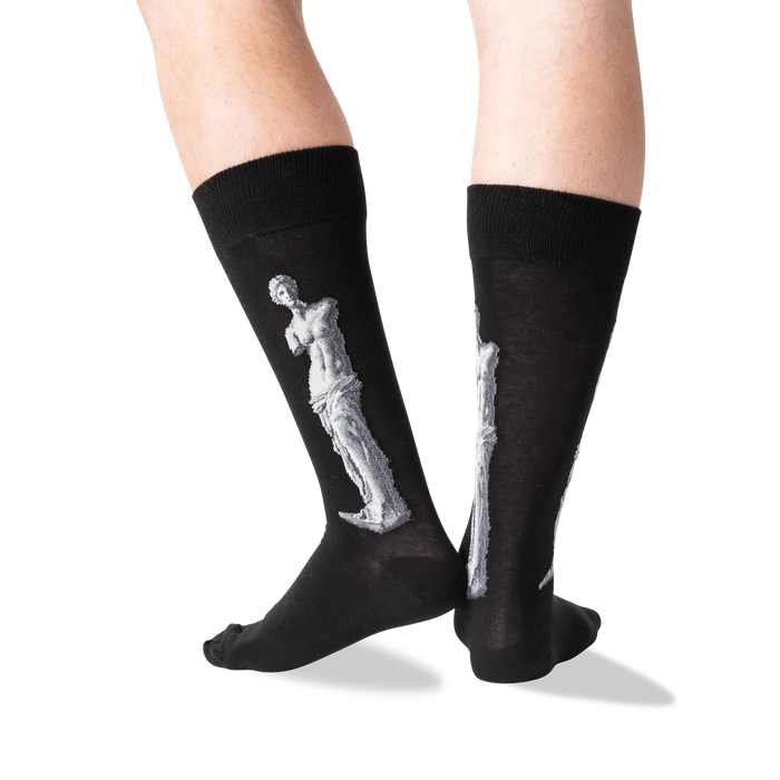 A pair of black socks with a white outline of the Venus de Milo statue on the back of each sock.