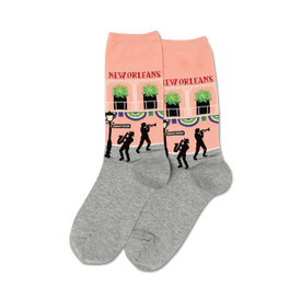 pink and gray crew socks with a bourbon street, new orleans pattern featuring musicians, palm trees, and balconies.  
