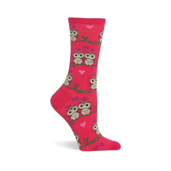 Pink crew sock with a pattern of cartoon owls, some in pairs, sitting on green branches. Small pink and purple hearts are scattered.