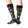 Back view of the dinosaur socks on a person's legs, highlighting the design details.