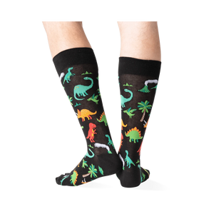 Back view of the dinosaur socks on a person's legs, highlighting the design details.