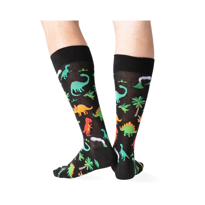 Back view of the dinosaur socks on a person's legs, highlighting the design details.