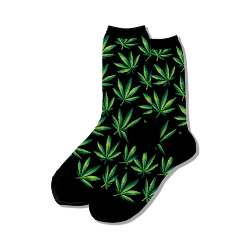 Close-up view of black crew socks with green marijuana leaf pattern.