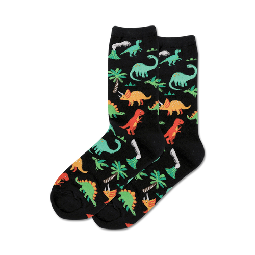 Pair of black crew socks with a fun pattern of colorful dinosaurs, palm trees, and volcanoes.