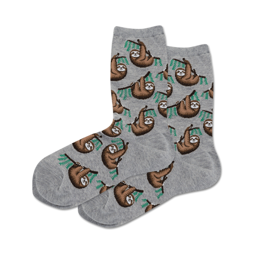 Lifestyle shot showing a pair of gray crew socks with a sloth pattern on a neutral background.