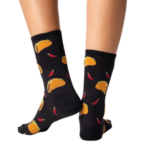 A pair of black socks with a pattern of tacos and chili peppers.