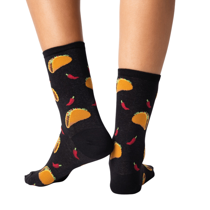 A pair of black socks with a pattern of tacos and chili peppers.