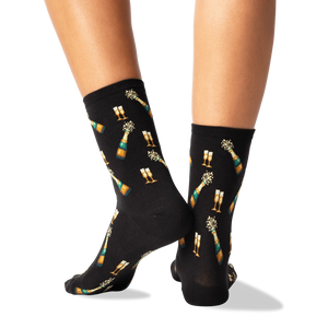A pair of black socks with a champagne bottle and two champagne glasses on them.