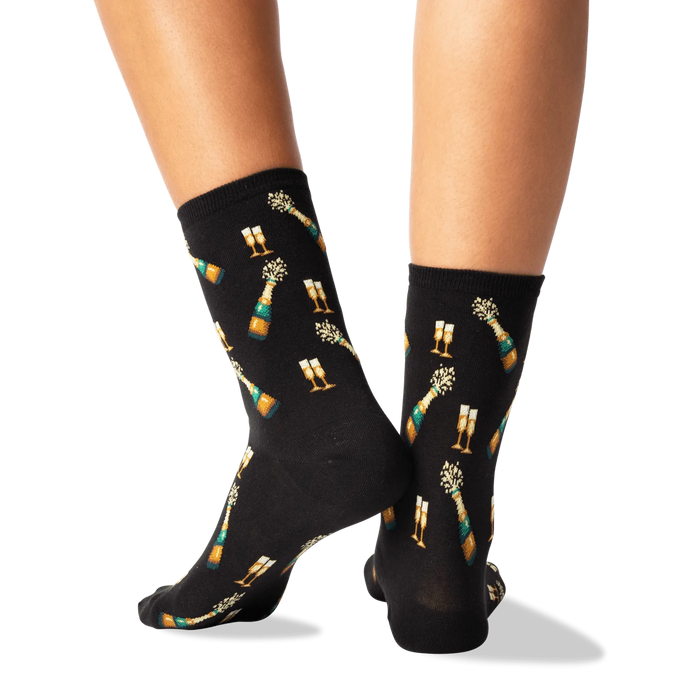 A pair of black socks with a champagne bottle and two champagne glasses on them.