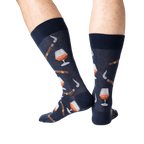 Lifestyle shot of a man's legs wearing the navy Cognac and Cigars socks.
