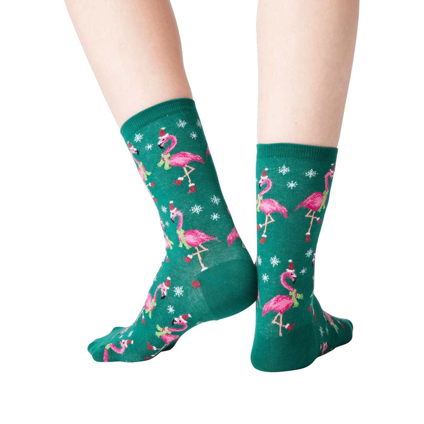 Back view of a person's legs wearing dark green crew socks with a pattern of pink flamingos wearing Santa hats.