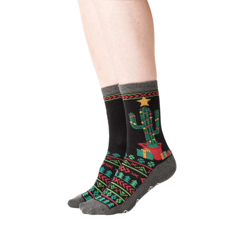 Lifestyle shot showing a person's legs wearing the Christmas Cactus Non-Skid Slipper socks.