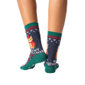 Rear view of model wearing a pair of Meowy Christmas socks.