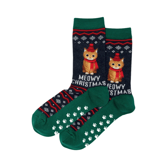 Pair of dark-blue and green crew socks. Christmas-themed fair isle pattern with orange cats wearing hats, and 'Meowy Christmas' text. Non-skid paw print soles.